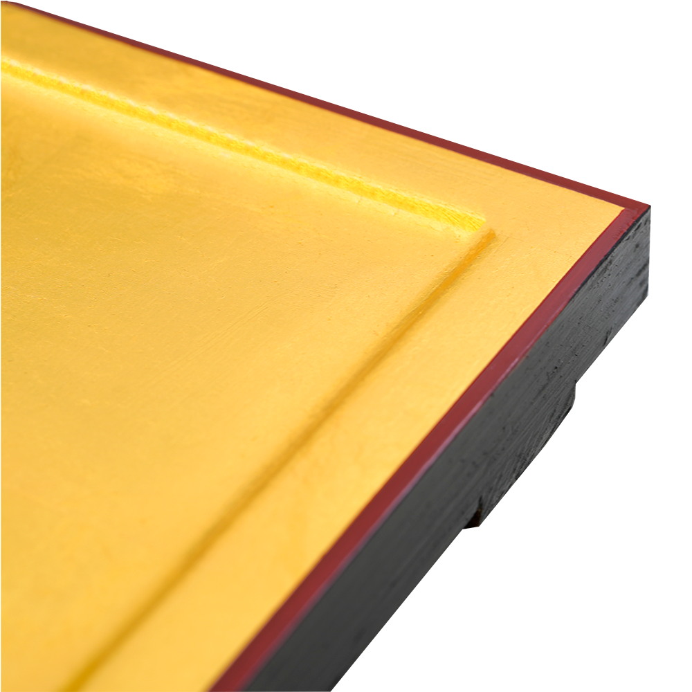 24 karat gold leaves at the edge of an engraved panel